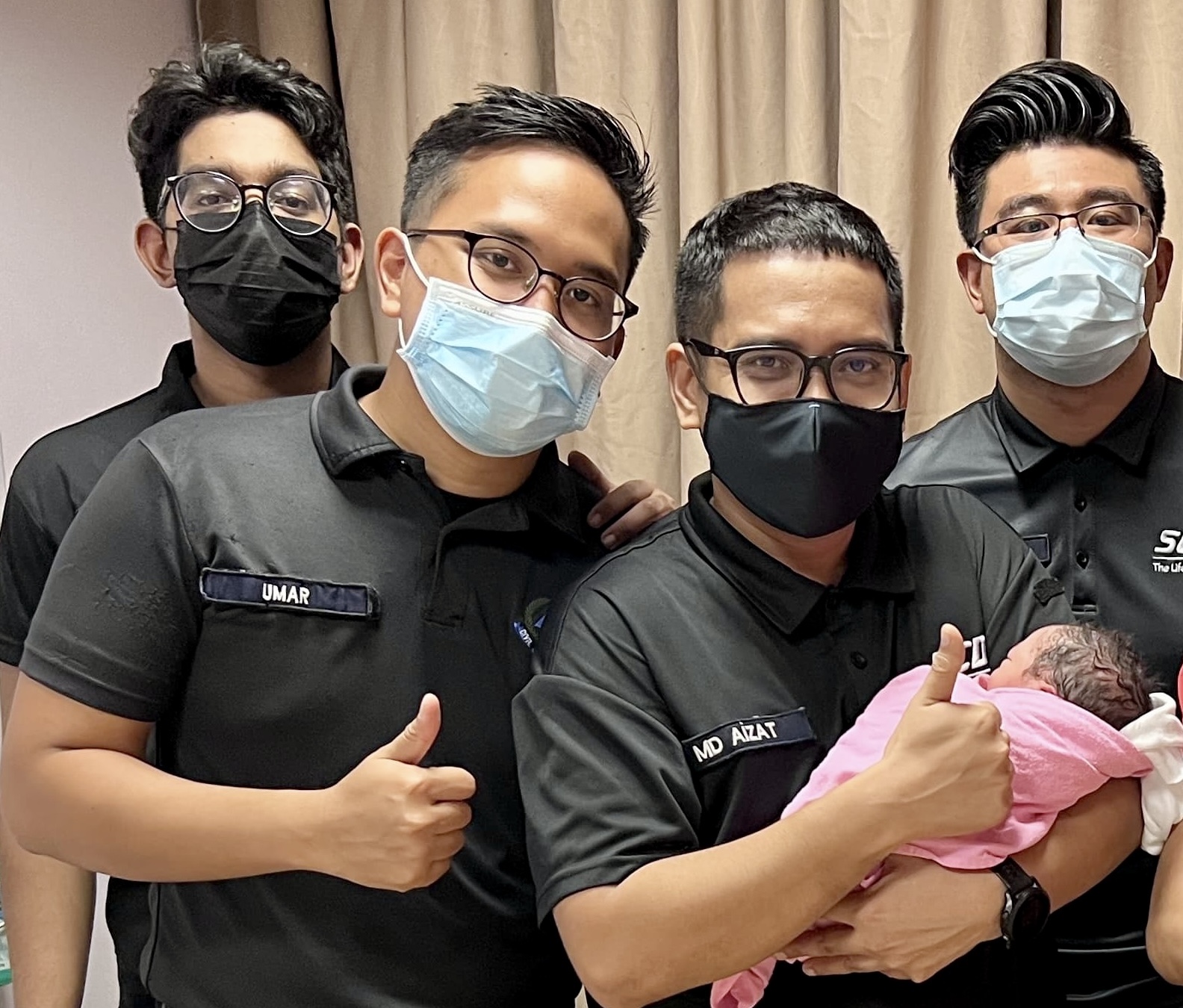 [From left to right] CPL (NS) Muhamad Affiq Malik,  SGT3 Umar Mohamed Sobri Bin Mohammad Khair, SGT3 Muhammad Aizat Bin Mohamad Salim  and WO1 Muhammad Husnul Bin Halim with the baby after the safe delivery.